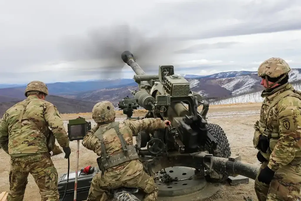 A gun crew from the 4th Brigade Combat Team, 25th Infantry Division, fire their M119 105mm howitzer during training at the Yukon Training Area located on Fort Wainwright, 7 May 2021. (United States Army) 