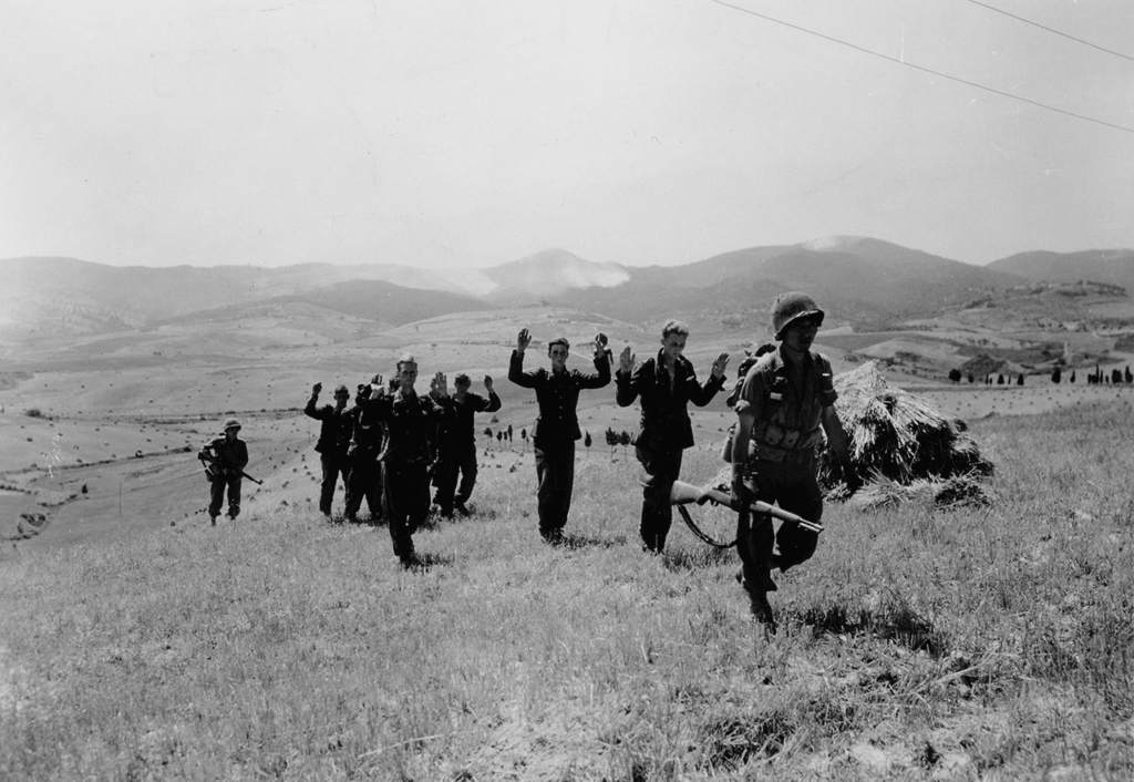 Riflemen of the 100th Infantry Battalion escort German prisoners who surrendered in the Orciano area of Italy, 15 July 1944. (National Archives)