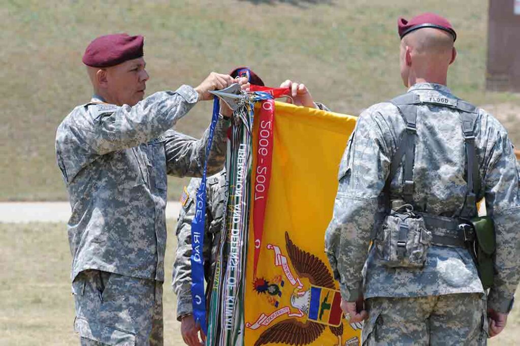 Major General Jim Higgins, commanding general of the 82d Airborne Division, attaches a Presidential Unit Citation streamer embroidered TURK VILLAGE, IRAQ, to the colors of 5-73 CAV, at Fort Bragg (now Fort Liberty), North Carolina, 26 May 2011. (U.S. Army)