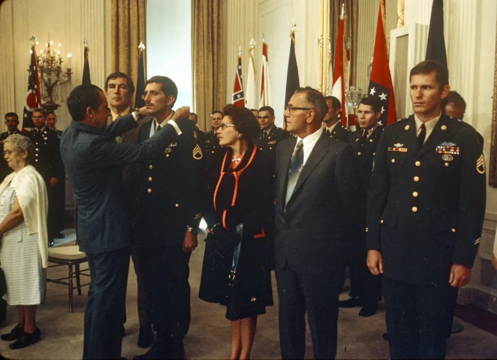 Staff Sergeant Miller is awarded the Medal of Honor by President Richard M. Nixon in the East Room of the White House, 15 June 1971, with the Miller family in attendance. (National Archives) 